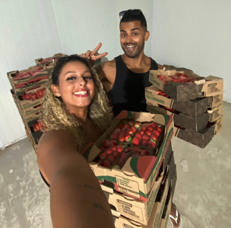 Casal com caixas de morangos selecionados